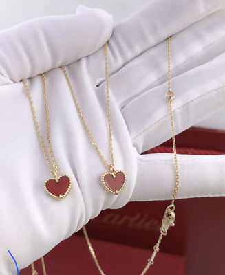 젊은 숙녀는 마노를 가진 심장 모양의 18K 금 목걸이를 선물합니다